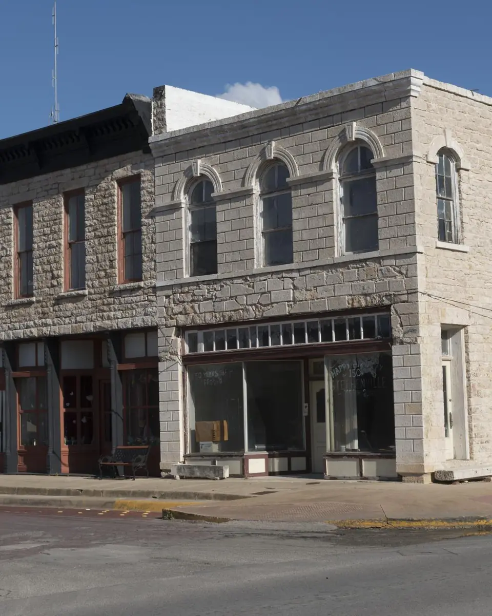 A two-story limestone commercial building on a downtown block in Stephenville, Texas